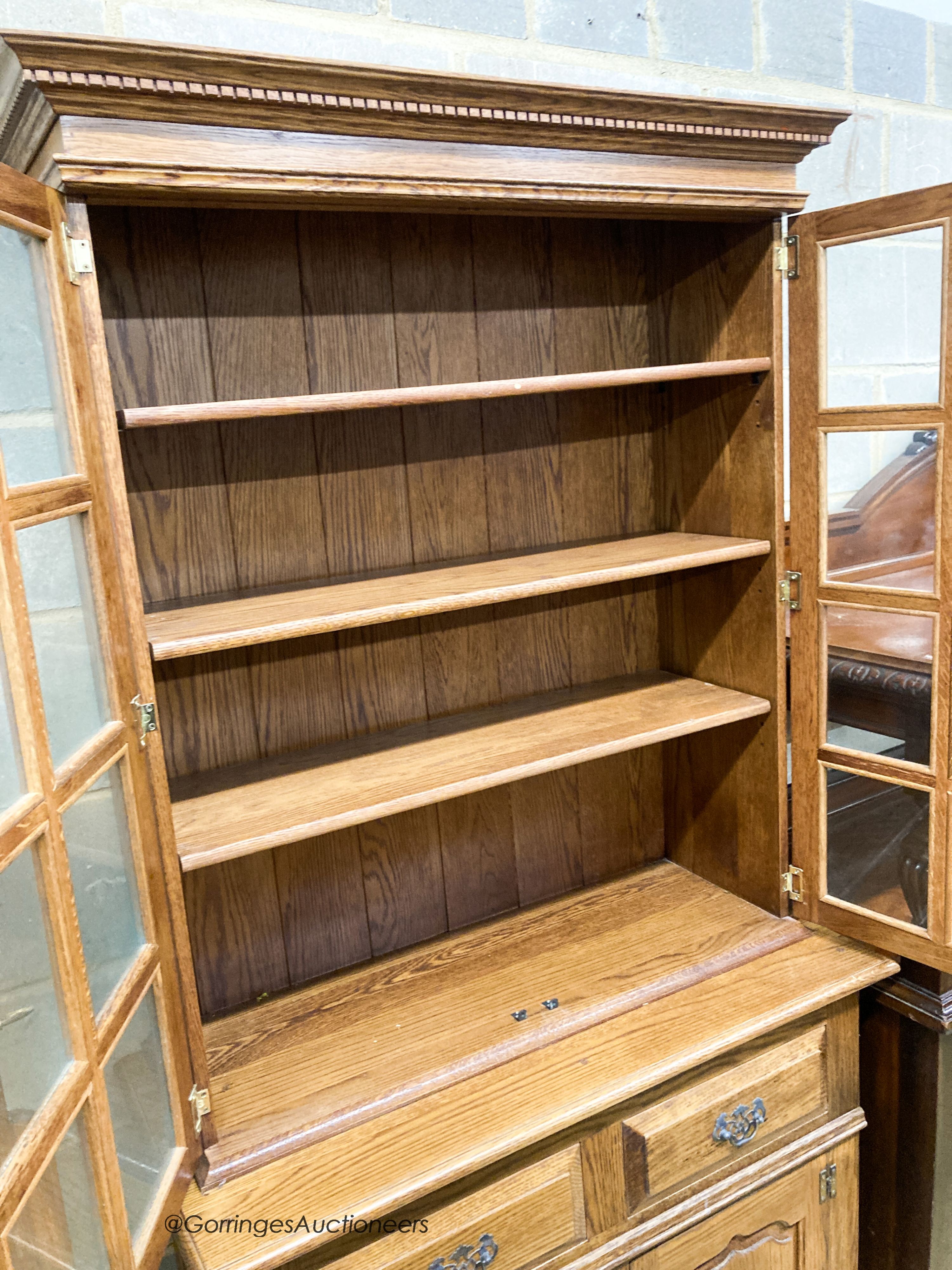 A reproduction oak bookcase cupboard, width 97cm, depth 43cm, height 190cm